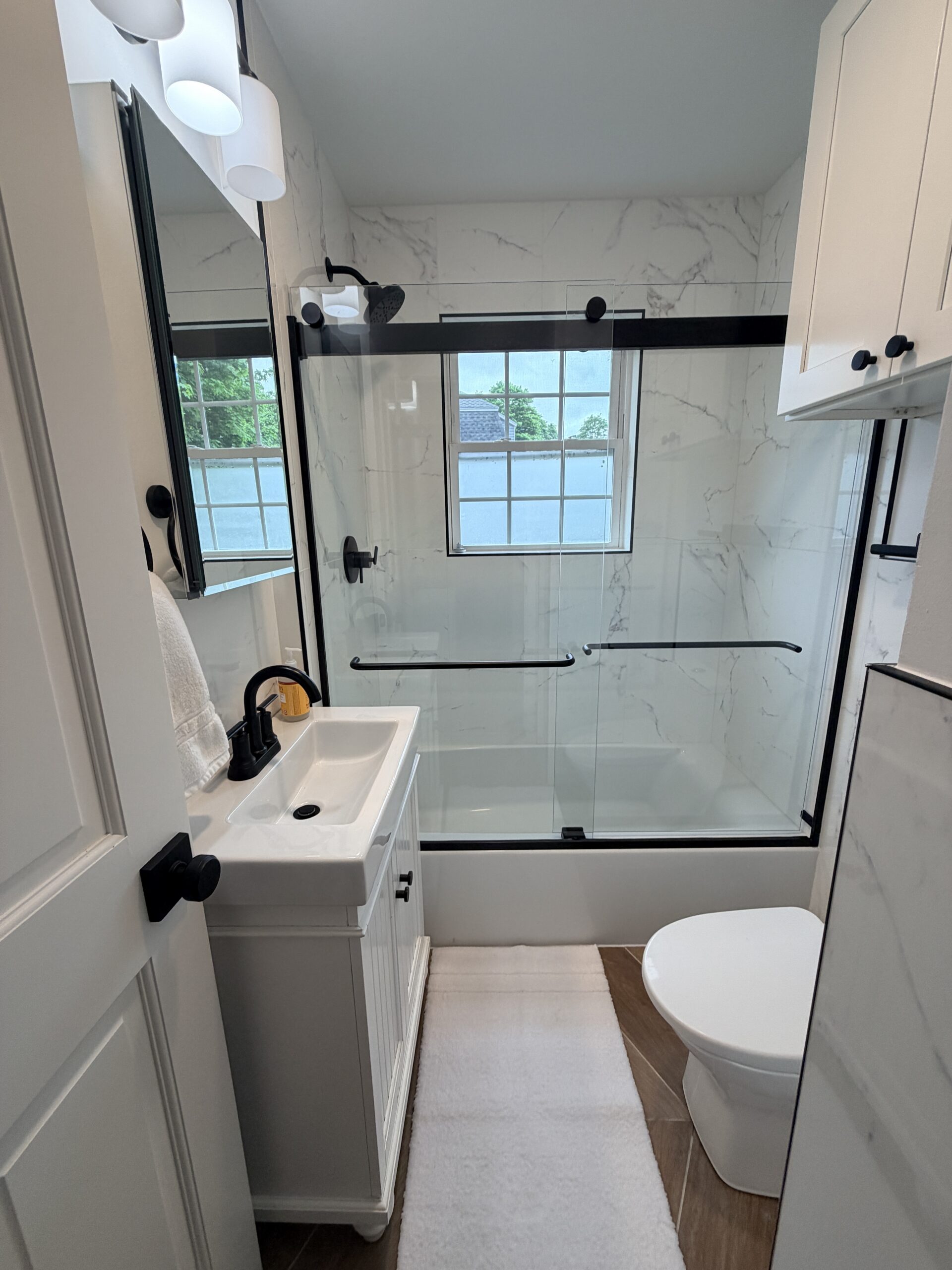 Natick bathroom remodel mirror reflection - frameless glass shower enclosure with Calacatta marble tile