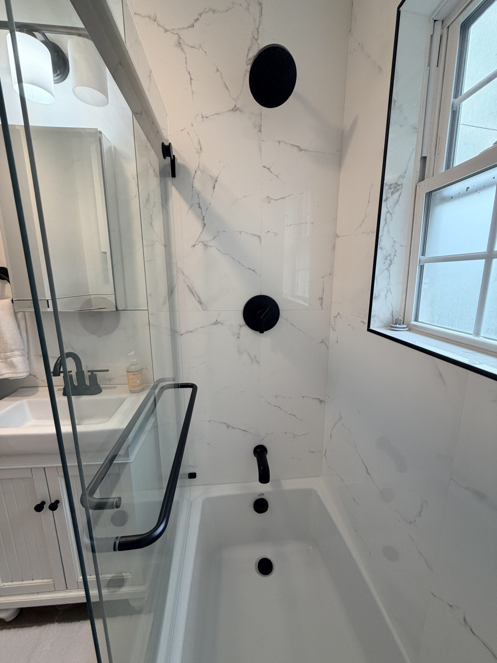 Natick bathroom remodel - Calacatta marble tile shower walls, matte black fixtures, ceiling shower head