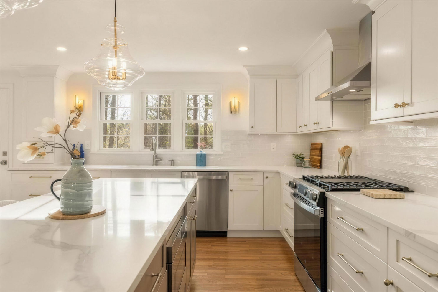 White Fabuwood Galaxy Dove kitchen cabinets with zellige tile backsplash, quartz countertops, champagne hardware and stainless range hood - kitchen remodeling in Medfield MA by Kitchen & Bath Center